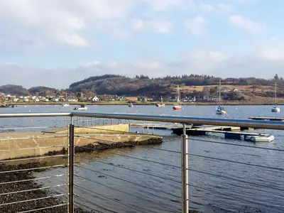a dock on the water with boats in the water at Ar Deireadh in Tayvallich
