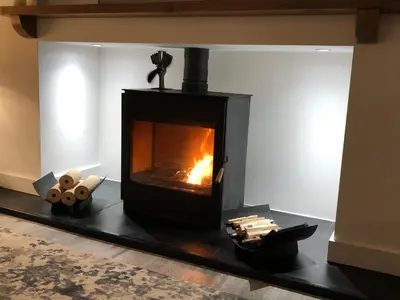 a fireplace in a living room with a fire at East Church House, Unique 9 bedroom Church, Historic Market Town. in Strathaven