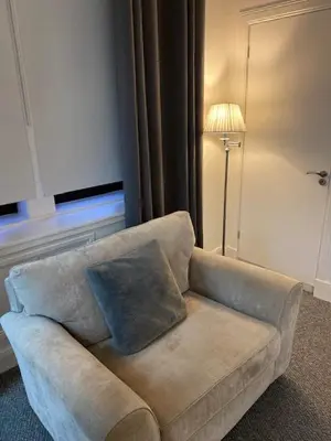 a couch in a living room with a lamp at Glenfinnan - Two Bedroom Apartment in Fife