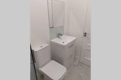 a white bathroom with a toilet and a sink at Glenfinnan - Two Bedroom Apartment in Fife