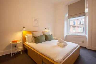 a bedroom with a large bed with a window at Stunning 2 bed property in heart of West End in Glasgow