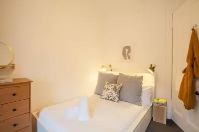 a small bedroom with a white bed with two pillows at Stunning 2 bed property in heart of West End in Glasgow