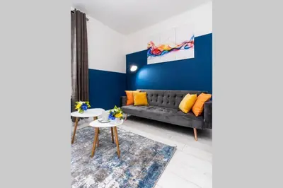 a living room with a couch and a table at Cheerful 2 Bedroom Homely Apartment, Sleeps 4 Guest Comfy, 1x Double Bed, 2x Single Beds, Free Parking, Free WiFi, Suitable For Business, Leisure Guest, Contractors, QE Hospital, Glasgow, Near Airport & City Centre, Perfect For Common Wealth Games 2026 in Glasgow