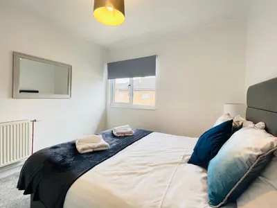 a bedroom with a bed with two towels on it at Cardonald Central in Glasgow