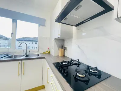 a kitchen with a stove top oven next to a sink at Cardonald Central in Glasgow