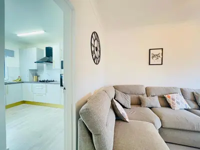 a living room with a couch and a kitchen at Cardonald Central in Glasgow
