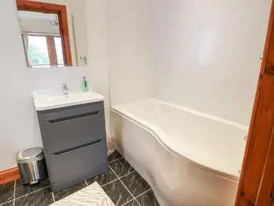 a bathroom with a bath tub and a sink at Torview House in Peebles
