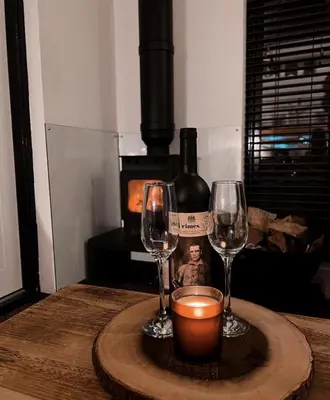 a table with two wine glasses and a bottle of wine at The Trossachs Collection in Kepculloch
