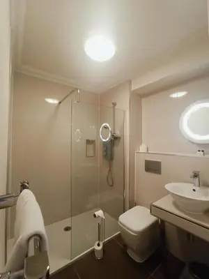 a bathroom with a shower and a toilet and a sink at Anchor Hotel and Seabed Restaurant in Tarbert