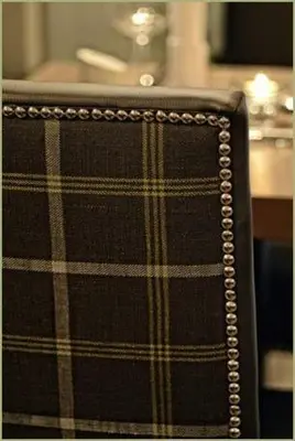 a close up of the back of a plaid chair at Anchor Hotel and Seabed Restaurant in Tarbert