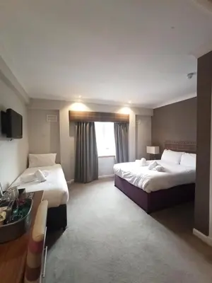 a hotel room with two beds and a window at Anchor Hotel and Seabed Restaurant in Tarbert