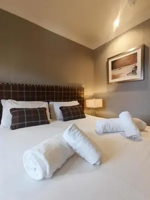 a bedroom with two white towels on a bed at Anchor Hotel and Seabed Restaurant in Tarbert