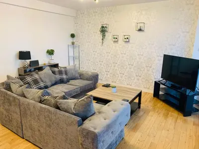 a living room with a couch and a flat screen tv at Modern 2 Bed Apartment, Close to Gla Airport & M8 in Paisley