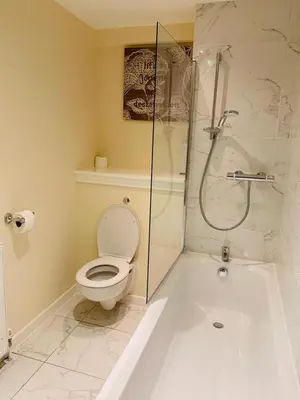 a bathroom with a toilet and a glass shower at Modern 2 Bed Apartment, Close to Gla Airport & M8 in Paisley