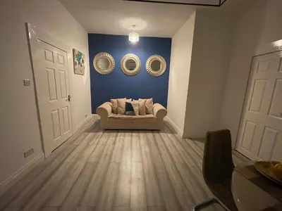 a living room with a couch and two mirrors at HLA Holytown in Mossend