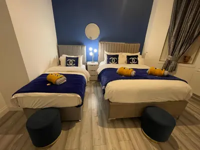 a bedroom with two beds with yellow pillows on them at HLA Holytown in Mossend