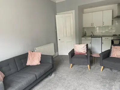 a living room with a couch and two chairs at Our Wee Getaway in Rothesay