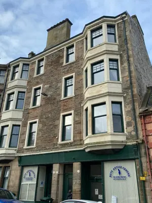 a large brick building with a clock on it at Our Wee Getaway in Rothesay