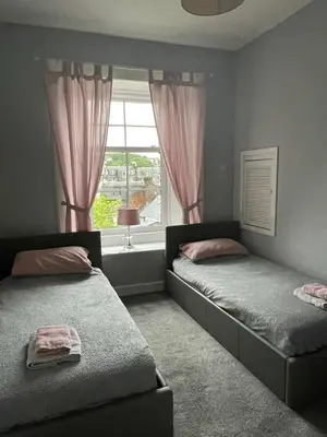 a bedroom with two beds and a window at Our Wee Getaway in Rothesay