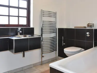 a bathroom with a toilet and a sink and a tub at Stronafian House in Feorlean