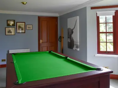 a green pool table in a room with a door at Stronafian House in Feorlean