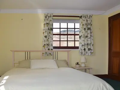 a bedroom with a white bed and a window at Stronafian House in Feorlean