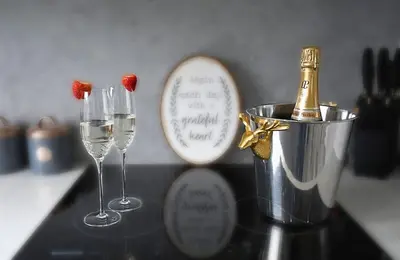 two wine glasses and a bottle of champagne on a counter at Gleneagles Luxury Apartments in Auchterarder