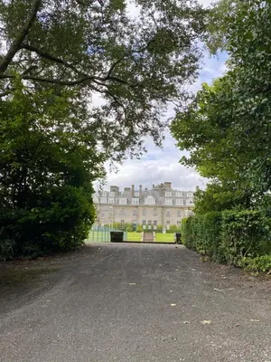 a large building in the middle of a park with trees at Gleneagles Luxury Apartments in Auchterarder