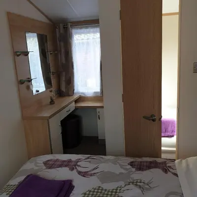 a bedroom with a bed and a desk and a window at Deer lodge in Auchterarder