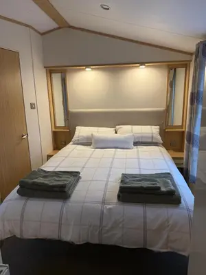 a bedroom with a bed with two towels on it at Deer lodge in Auchterarder