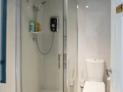 a bathroom with a shower with a toilet and a glass shower at Bumbles Barn in Slamannan