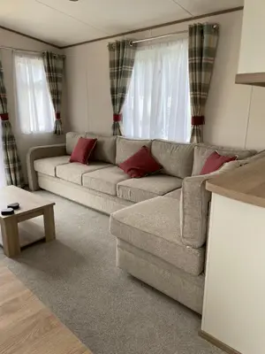 a living room with a couch and two windows at The Wimbledon 70 in Dunoon