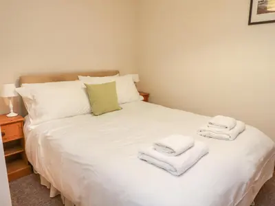 a bedroom with a white bed with towels on it at MacKintosh in Pitlochry