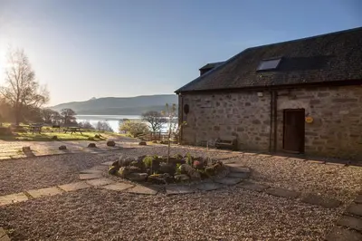 a stone building with a garden in front of it at MacKintosh in Pitlochry