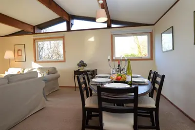a dining room with a table and chairs and a couch at Musselshell Lodge in Otter Ferry