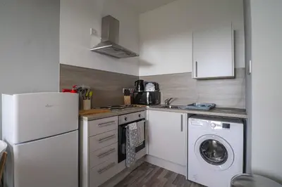 a kitchen with a white refrigerator and a washing machine at Townend Apartment in Dumbarton