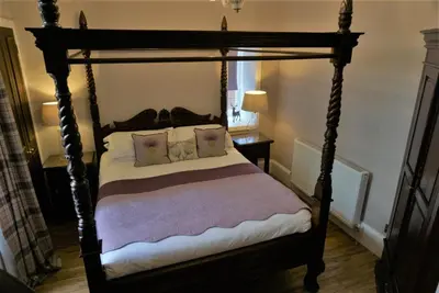 a bedroom with a canopy bed with pillows at Old Town 163 in Edinburgh