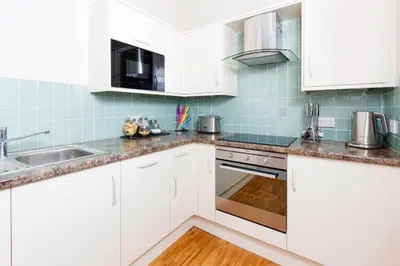 a kitchen with white cabinets and a sink at Old Town 163 in Edinburgh