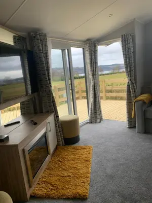 a living room with a tv and a large window at The Castleton Sea View 13 in Dunoon