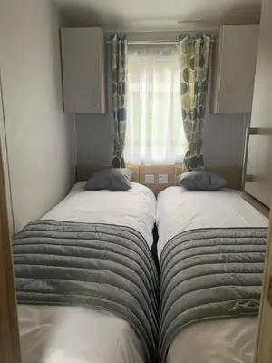 two beds in a small room with a window at The Castleton Sea View 13 in Dunoon