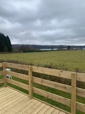 a wooden fence with a field in the background at The Castleton Sea View 13 in Dunoon
