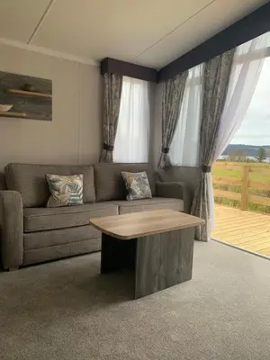 a living room with a couch and a table at Swift Bordeaux Sea View No 3 in Dunoon