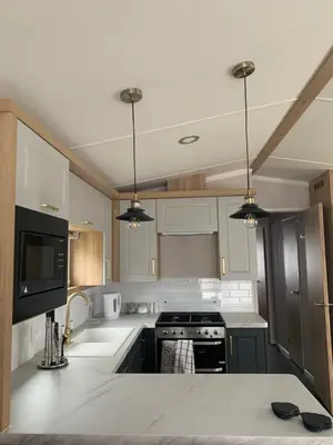 a kitchen with white cabinets and a white counter top at Swift Bordeaux Sea View No 3 in Dunoon