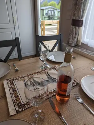 a table with a bottle of whiskey and a glass at Swift Bordeaux Sea View No 3 in Dunoon