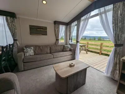 a living room with a couch and a table at Swift Bordeaux Sea View No 3 in Dunoon