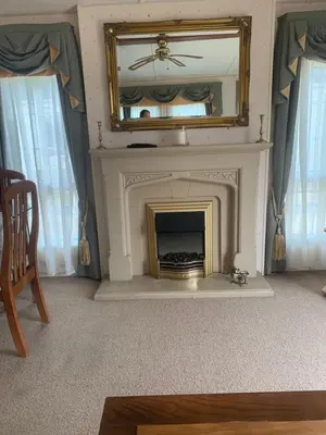 a living room with a fireplace with a mirror at The Monaco 32 in Dunoon