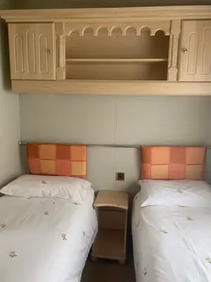 two twin beds in a room with a cabinet above them at The Monaco 32 in Dunoon