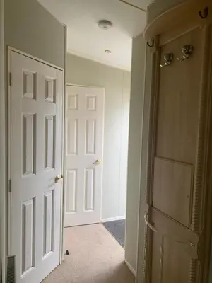 an empty hallway with two white doors in a room at The Monaco 32 in Dunoon