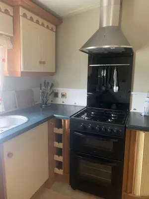 a kitchen with a black stove and a sink at The Monaco 32 in Dunoon