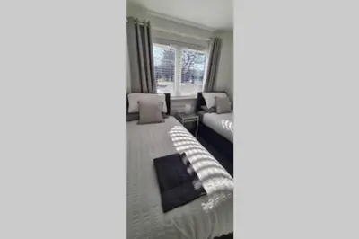 a bedroom with a bed and a window at Craiglynn Holiday Apartment Loch Lomond in Balloch